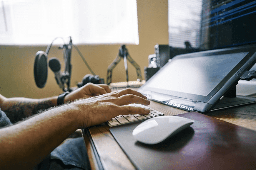 Man typing on his foldable laptop, working on his content creation.